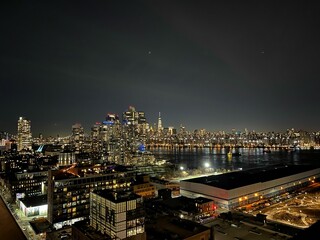 Naklejka premium Stunning aerial view of a large city skyline illuminated with bright lights at night