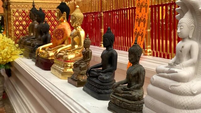 Sitting Buddha statues in front of temple in Thailand