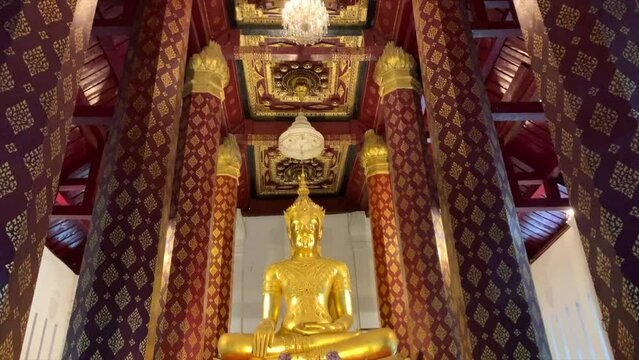 Golden Buddha statue inside temple in Thailand