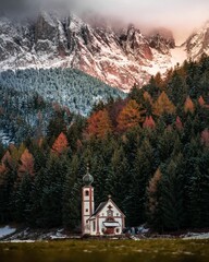 a small church is in the middle of a snow covered mountain