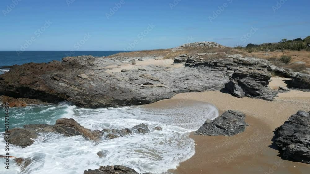 Canvas Prints slow motion of the foamy sea waves hitting the rocks and the sandy shore in otago, new zealand