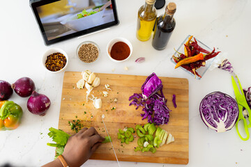 Hands of plus size african american woman in apron preparing meal using tablet in kitchen
