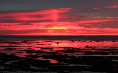 Spectacular sunset above the ocean, with vibrant oranges and pinks filling the sky above the horizon