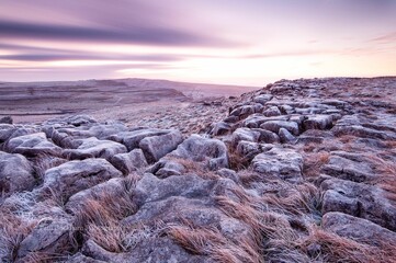 Idyllic landscape with the sun rising over mountains in the background in Malham, England