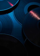 Artsy shot of vintage vinyl records illuminated by a soft blue light