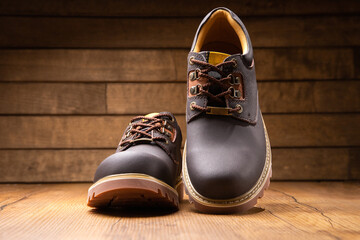 Stylish men's casual work boots for everyday walking in nature and the city on a wooden background...