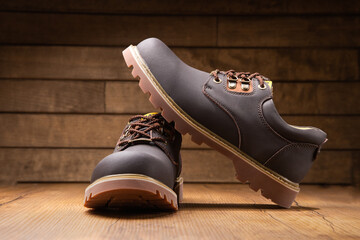 Stylish men's casual work boots for everyday walking in nature and the city on a wooden background...