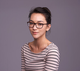 Portrait, fashion glasses and serious woman in studio isolated on a gray background mockup space. Face, nerd and female geek, person or model from Canada with trendy clothes, eyewear and casual style