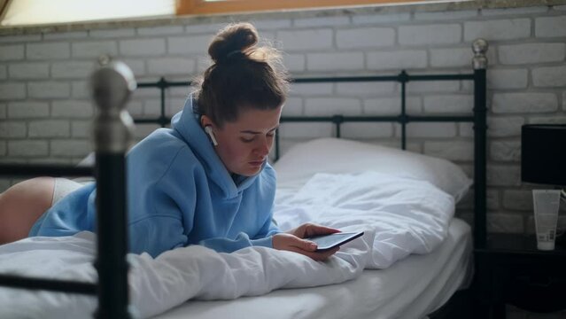Woman reads e-book in her bed, 4k