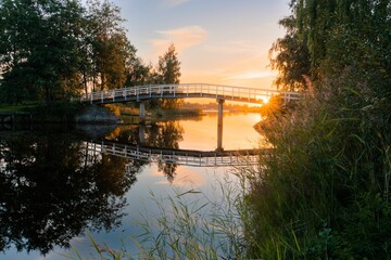 Landscape of a bridge over a lake in a forest during a beautiful sunrise