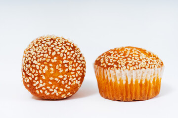 sweet cupcakes with sesame seeds on a white background. flour sweets. muffins with sugar and seeds in a basket on a light background