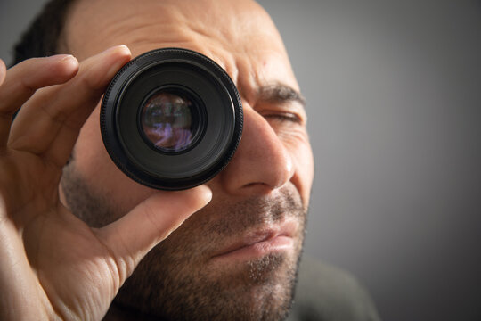 Man looking through camera lens.