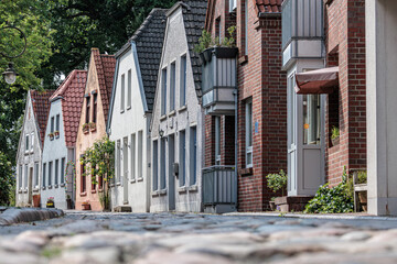 Historic residential buildings in Jever on a narrow cobblestone street