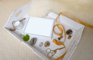 on wooden white tray lies empty white frame for message, designer text, rustic paper bundle mocap...
