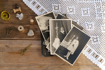 old vintage monochrome photographs scattered on rustic wooden table, dear to heart memorabilia,...