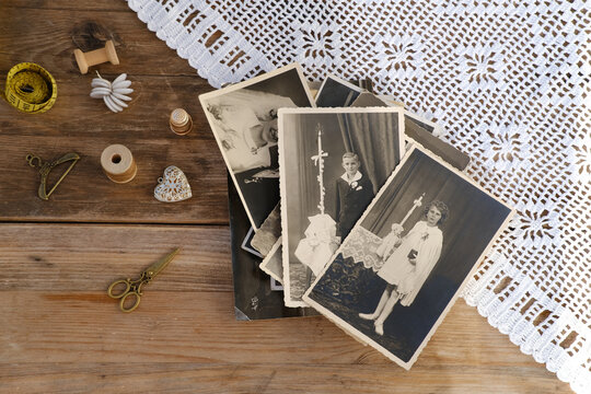 old vintage monochrome photographs scattered on rustic wooden table, dear to heart memorabilia, decor, concept family tree, genealogy, childhood memories, retro inspiration, old-fashioned charm