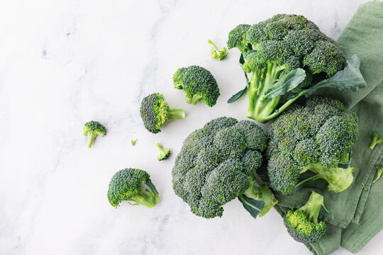 Heap of fresh green broccoli on stone table top view.