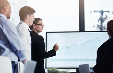 Mentor, monitor or business people in a presentation for chart report or graphs analysis in a meeting. Data analytics, woman manager or speaker planning sales growth on screen monitor in mentorship