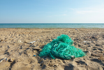 Part of a fishing net on a sandy shore