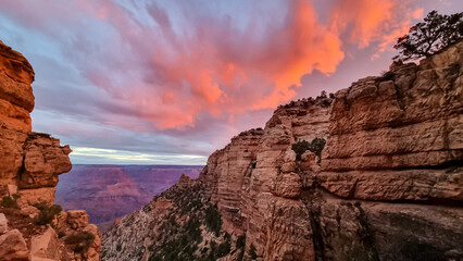 Panoramic aerial view from Bright Angel hiking trail at South Rim of Grand Canyon National Park, Arizona, USA. Vista after sunrise in summer. Sky is shining in vivid orange red colors