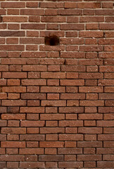 background of Vintage red brick wall frame. Small hole in wide brick wall.