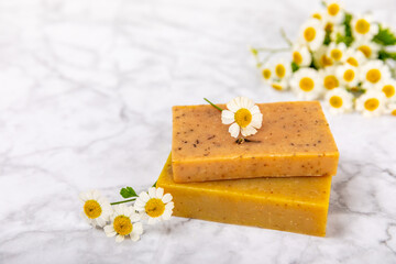 Natural homemade soap with chamomile flowers on a marble background. Spa procedure. Beauty concept. Body skin care. Place for text. copy space.