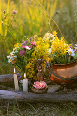 Triple Goddess Candlestick, Copper witch cauldron with flowers, magic things, candles on meadow,...