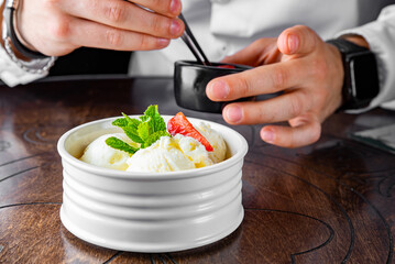 chef hand decorated ice cream in white bowl close up