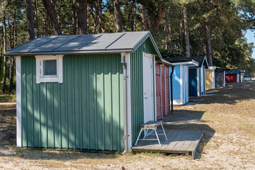 Colorful beach huts, little wooden houses on the beach, glamping tourism