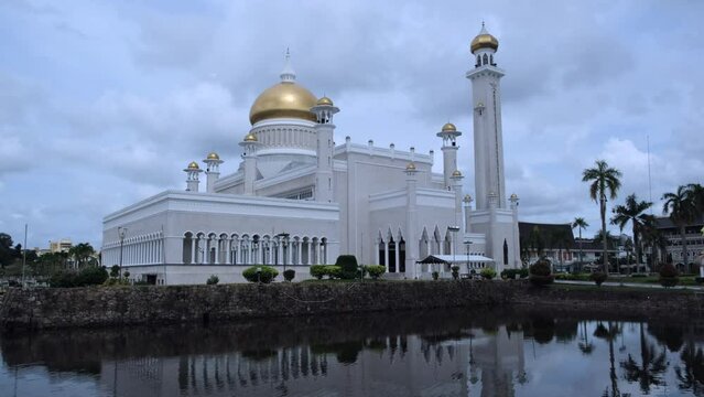 View of Omar Ali Saifuddien Mosque in Bandar Seri Begawan, Brunei reflecting on the water at sunset