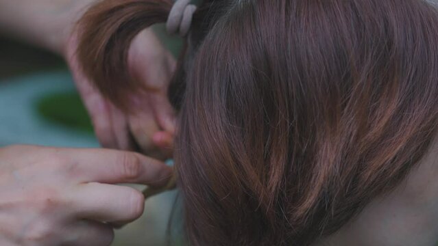 Process of weaving making boxer braids cornrows by a hair braider.