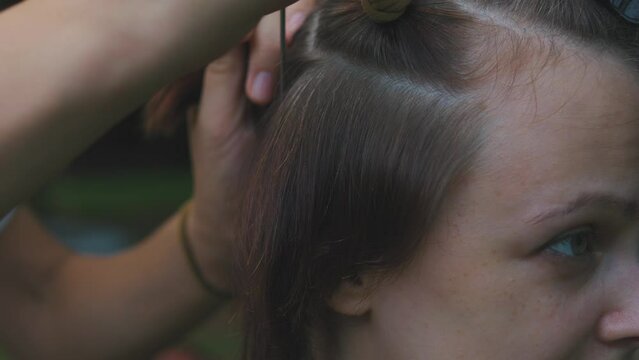 Process of weaving making boxer braids cornrows by a hair braider.