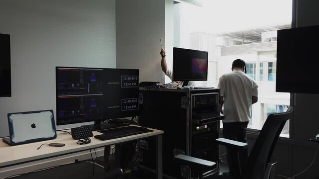 Slow tracking shot of technicians setting up for the streaming event