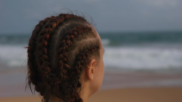 Close up of caucasian girl with boxer braids cornrows on the beach.