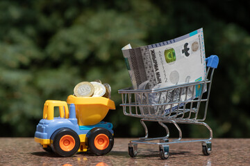 Banknote of 20,000 Kazakhstani tenge in a miniature shopping cart from a supermarket on a natural background