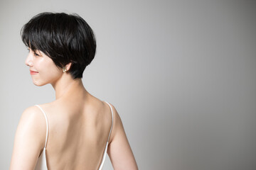 アジア系女性の美しい背中や肩甲骨　振り返る見返り美人の図　右にコピースペースあり