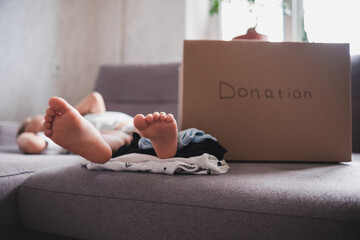 Cardboard donation box and little child at home