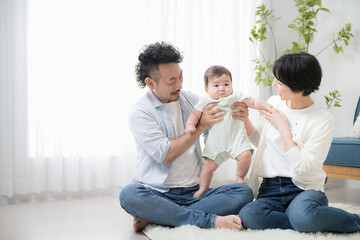 Family in living room with cute Asian baby
