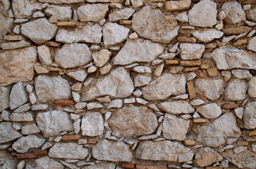 Old stone wall with ceramic pieces close