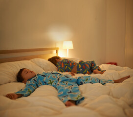 Brothers, sleep and night in bed for rest together, peace and health in family home. Young tired...