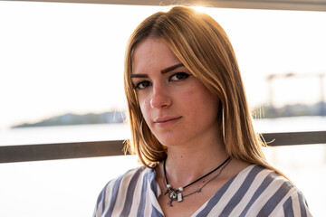 portrait of a young beautiful woman sitting on a boat sailing during summer vacation