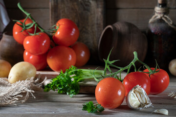 Red tomatoes and other vegetables on a rustic table