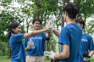 volunteers holding, doing hands up together for powerful volunteering charity, group of volunteers join together to cleanup ,collect garbage, separate waste. concept for earth day