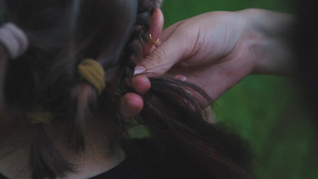 Process of weaving making boxer braids cornrows by a hair braider.