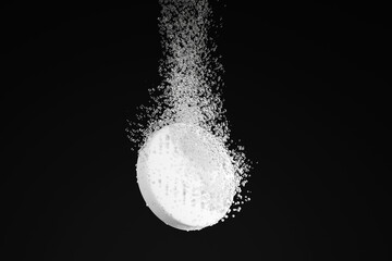 Dispersible aspirin sinking and dissolving into clear water on black background. Illustration of the concept of soluble pills and pharmaceutical industry - obrazy, fototapety, plakaty
