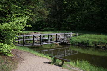 Drewniane mostki nad rzeką i jeziorem. Miejsce spacerów i wędkowania.