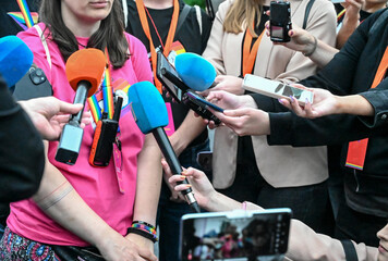 Lots of microphones at the press conference. Recording audio. Journalism. The hands of reporters...