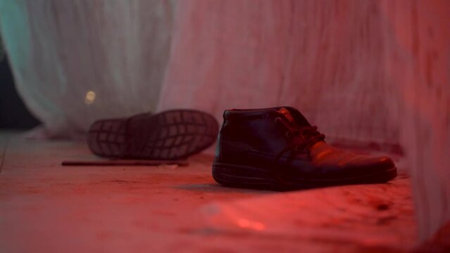 Male picks up a knife from the bloody floor