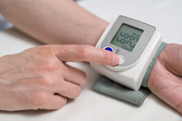 Measuring blood pressure at home. modern digital blood pressure monitor on a female wrist - obrazy, fototapety, plakaty