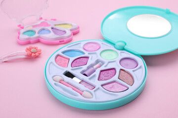 Obraz na płótnie Canvas Decorative cosmetics for kids. Eye shadow palettes on pink background, closeup